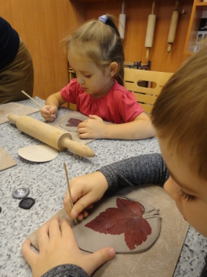 Dzieci za pomocą patyczka wykreślają odciśnięte w glinie listki;-)))